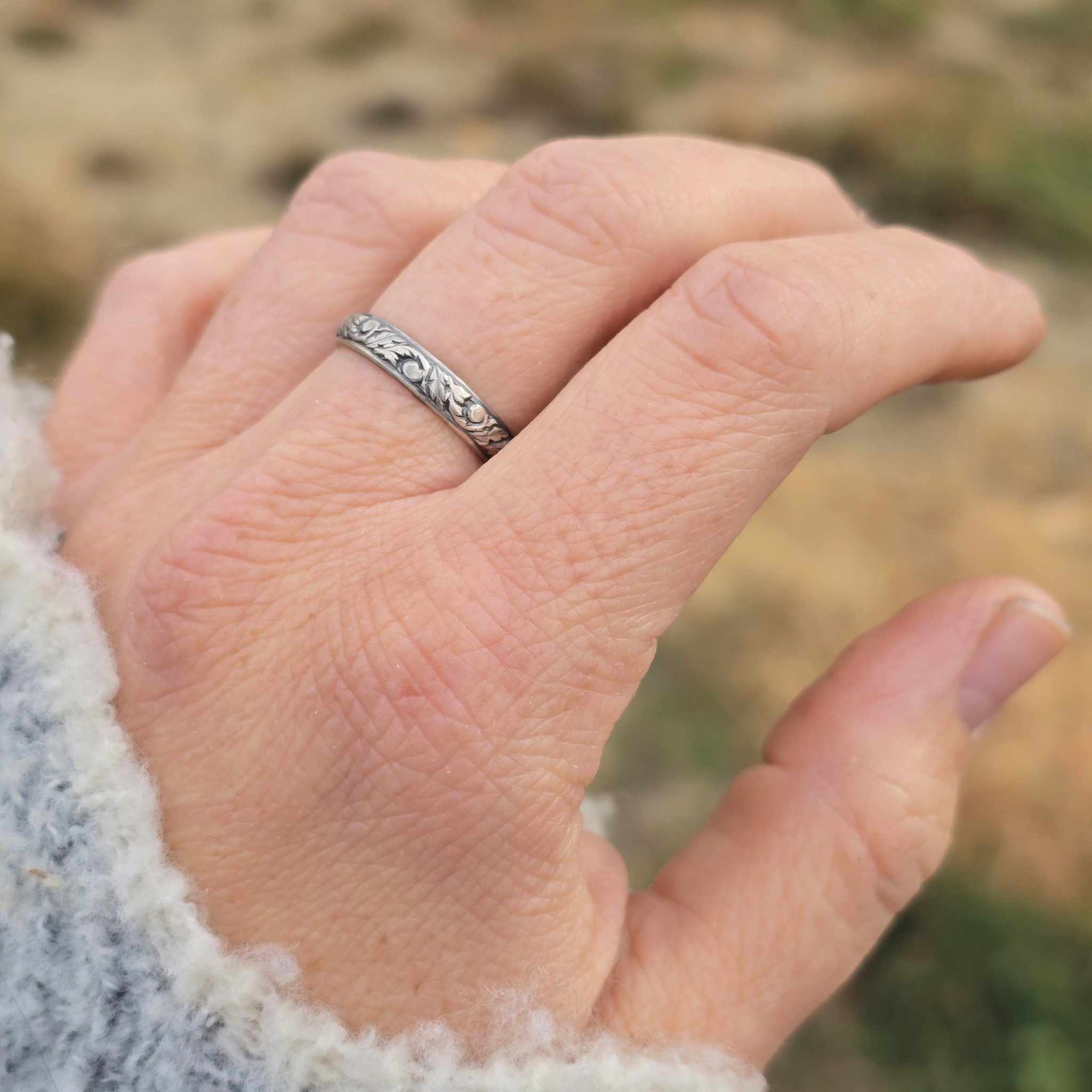 Leaf pattern dark sterling silver ring shown on hand