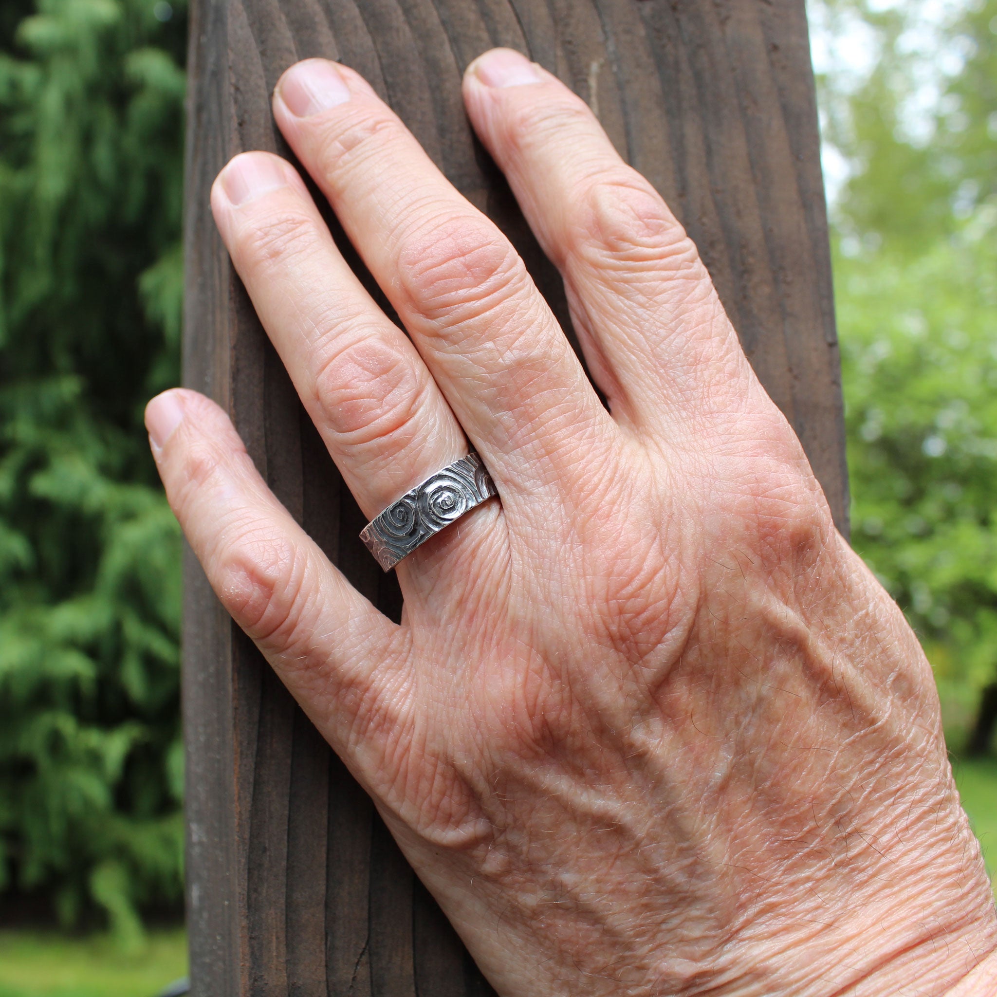 Handmade carved spiral ring shown on hand