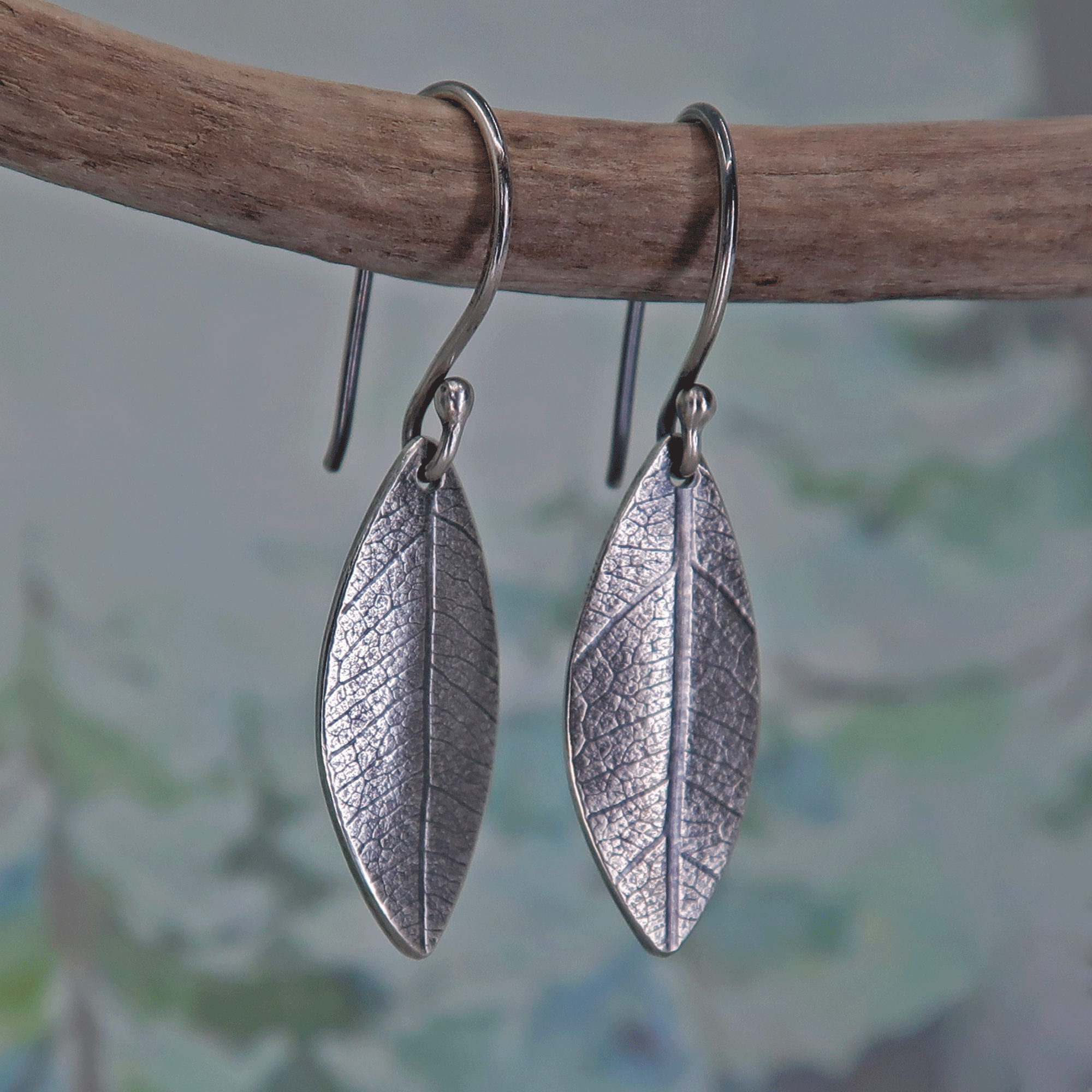 Botanical-style silver earrings with delicate embossed leaf imprint