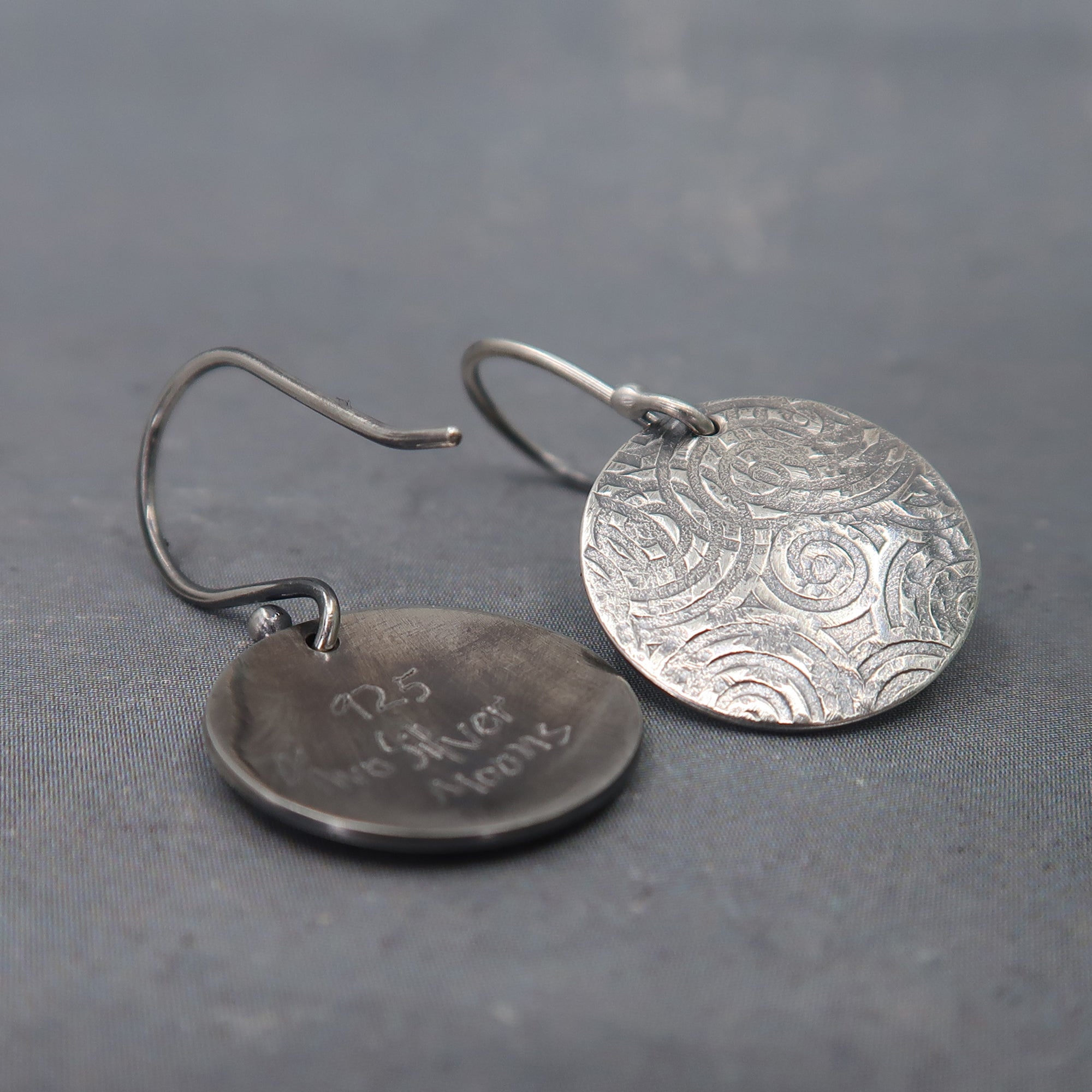 Handcrafted silver earrings embossed with ancient spiral design, front and back view