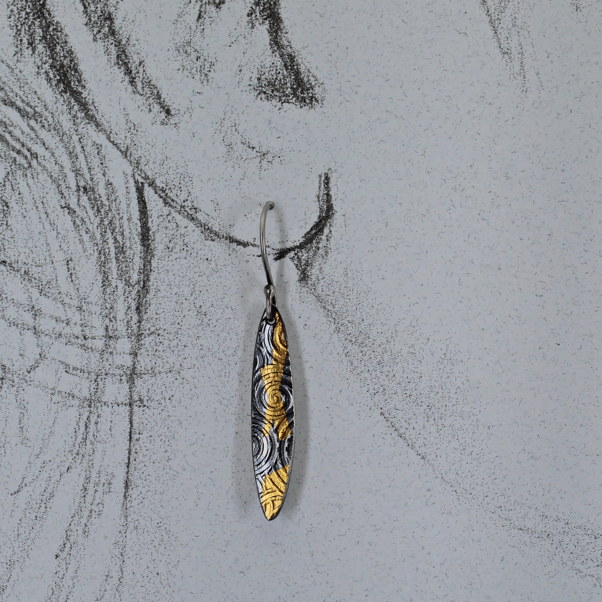 Full view of long silver earrings with handcrafted ear wires shown on a life size ear drawing