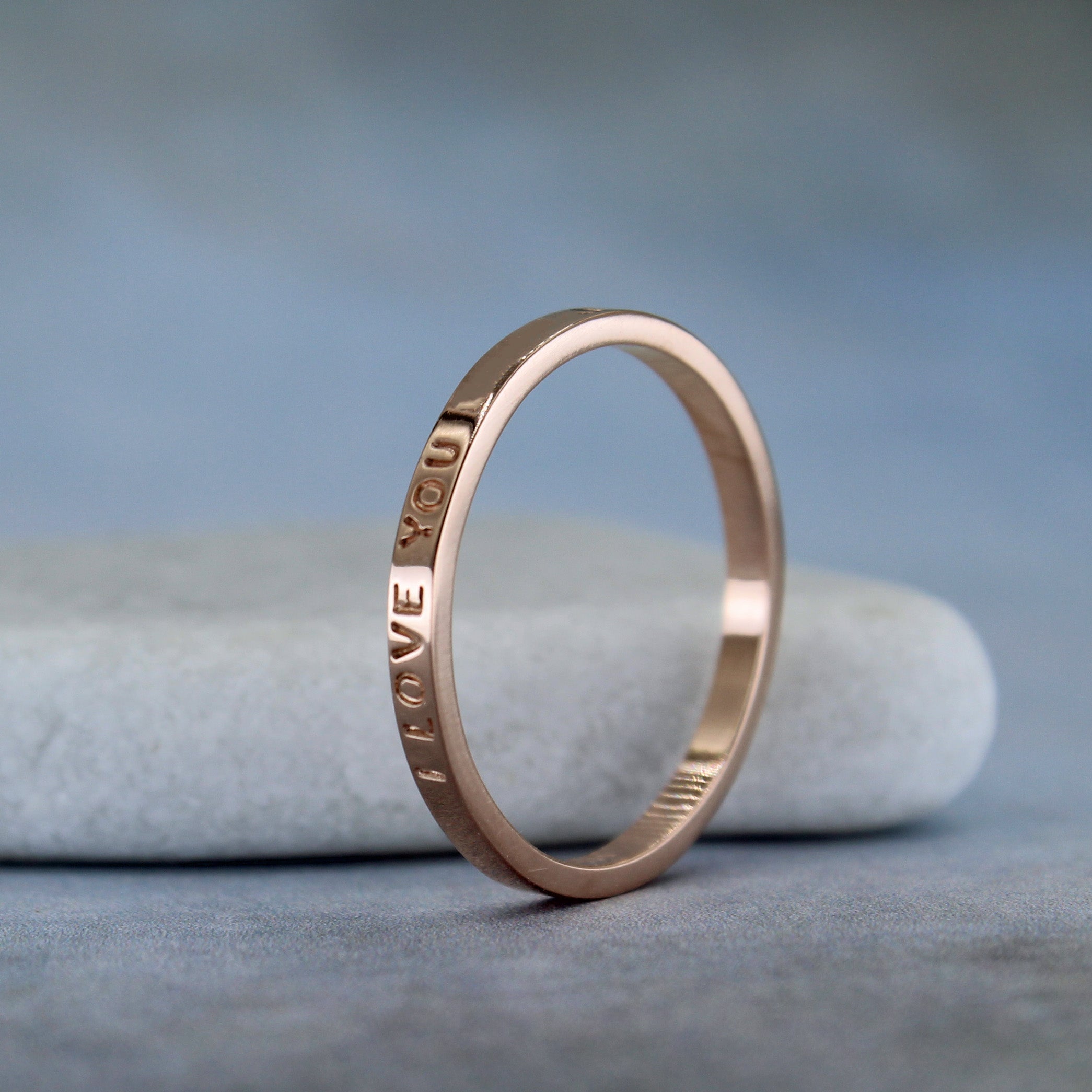 2 mm polished rose gold stacking ring shown with custom inscription on the outside