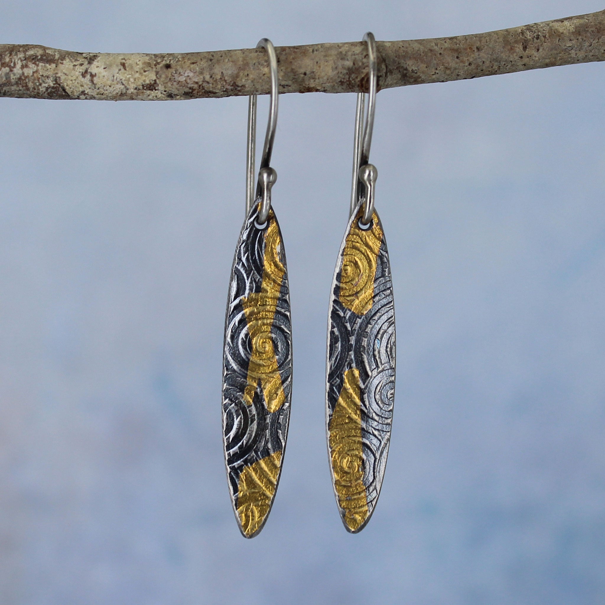 Handmade artisan earrings, long ovals with ancient spiral pattern. Made in sterling silver with 23k gold accents