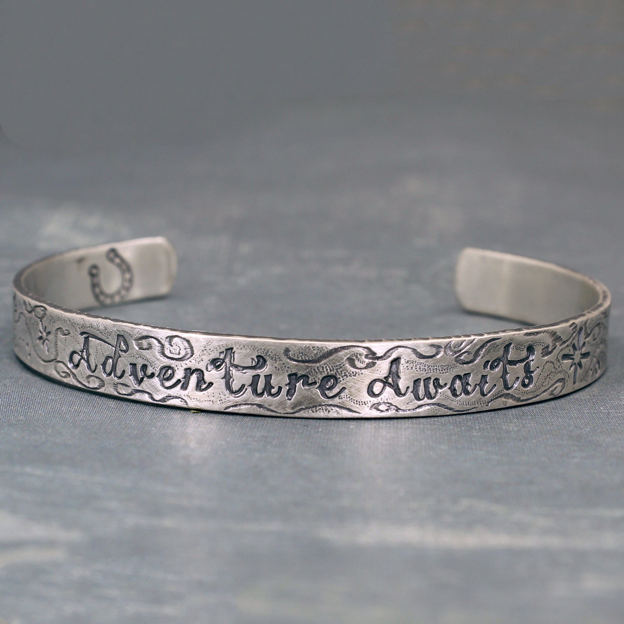 Adventure Awaits bracelet cuff– shows inscription and surface texture