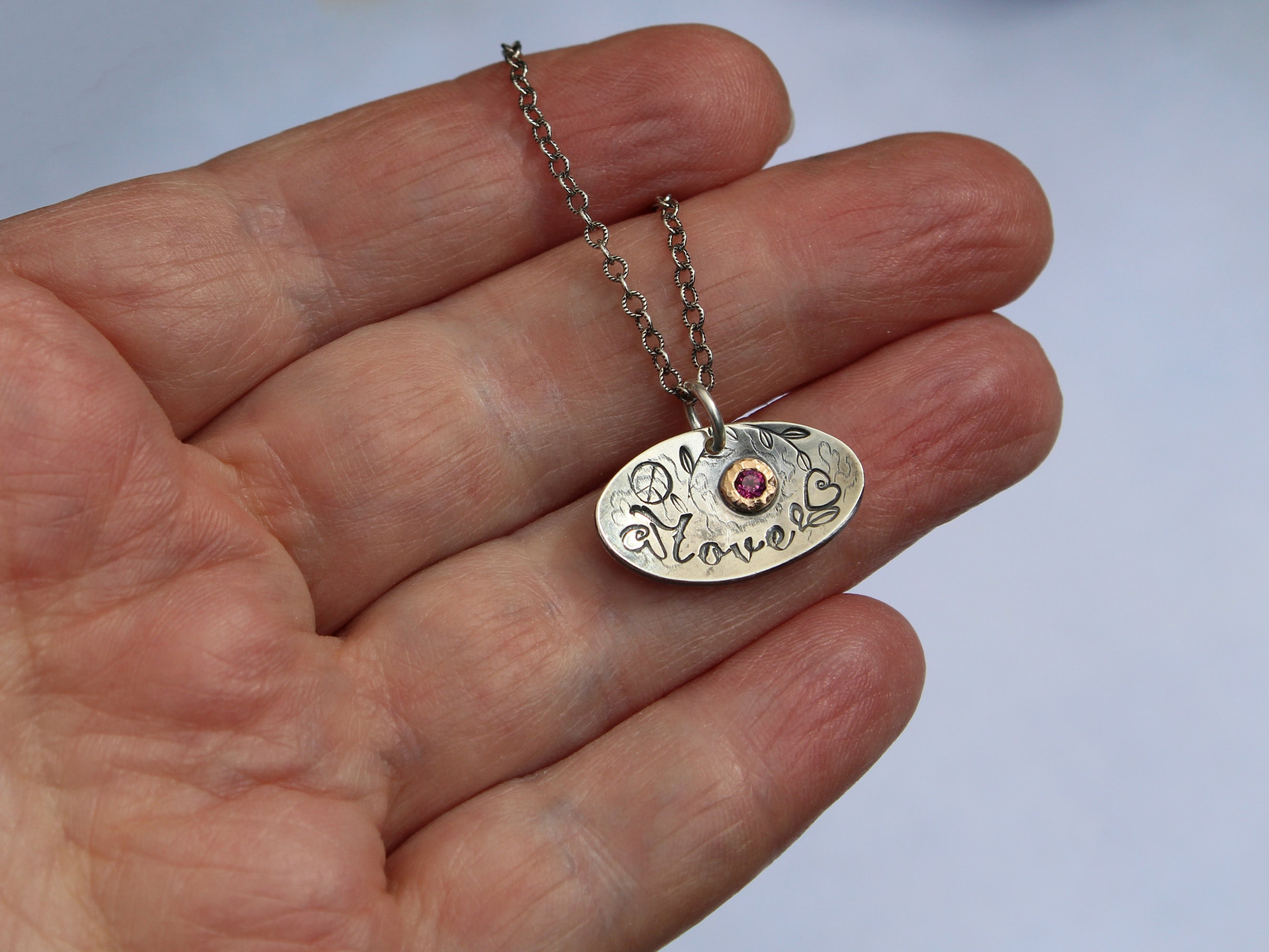 Love necklace shown on hand