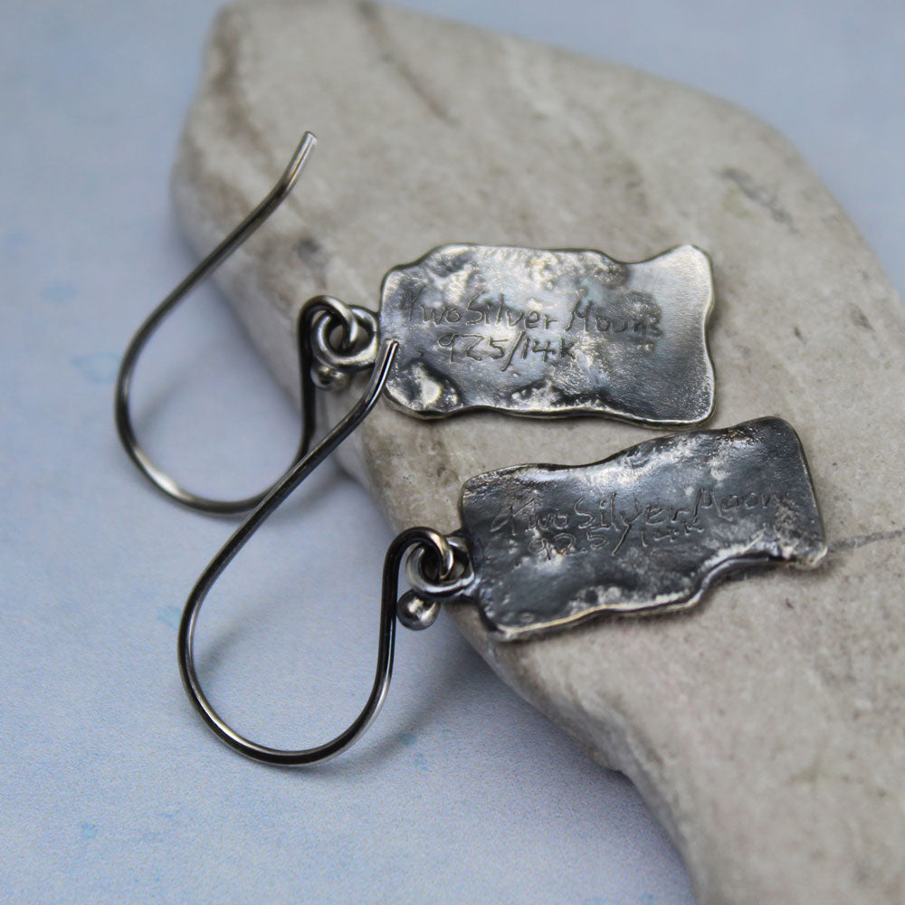 Earrings showing from the back with signature of artist