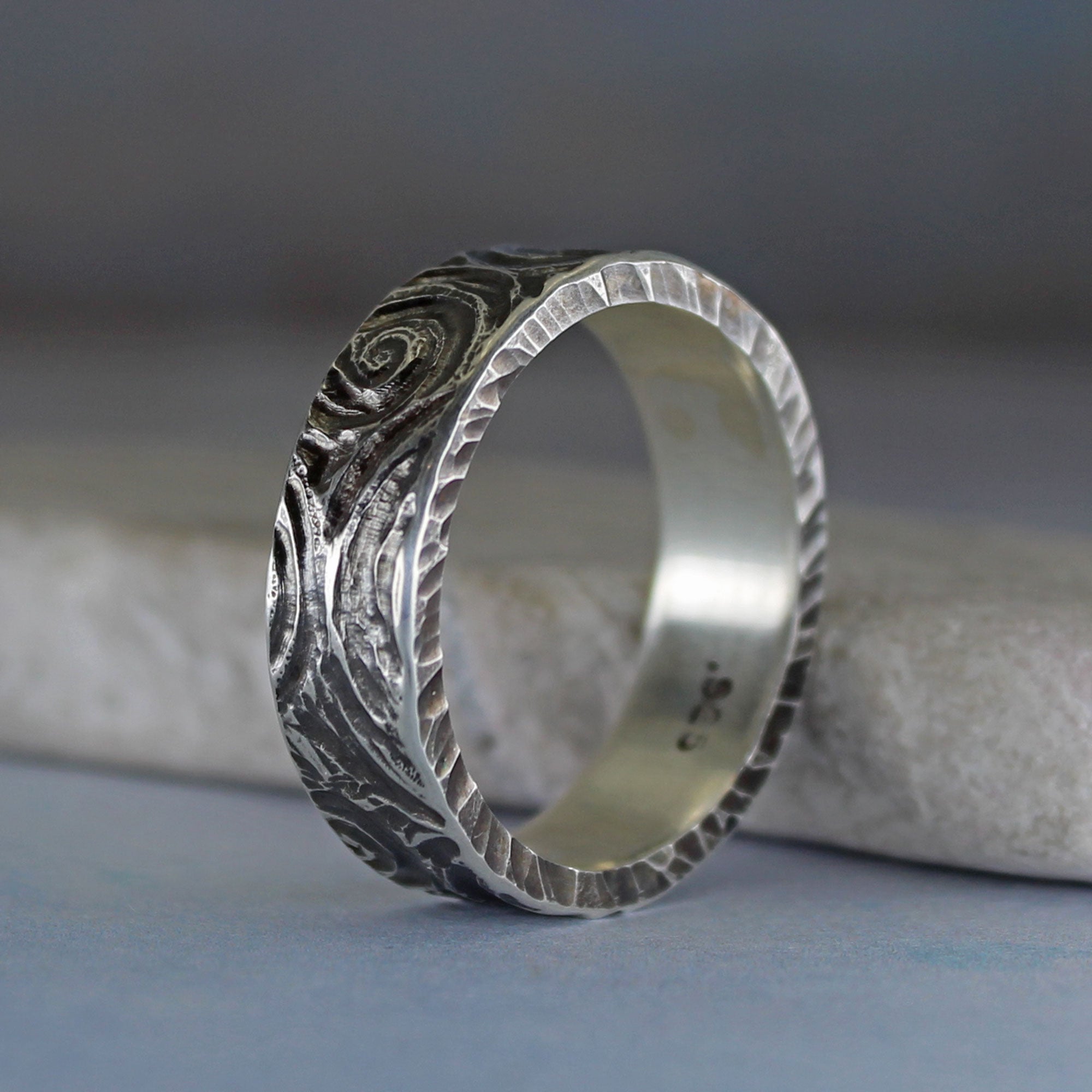 Side view of 6 mm sterling silver ring with hand carved spiral pattern