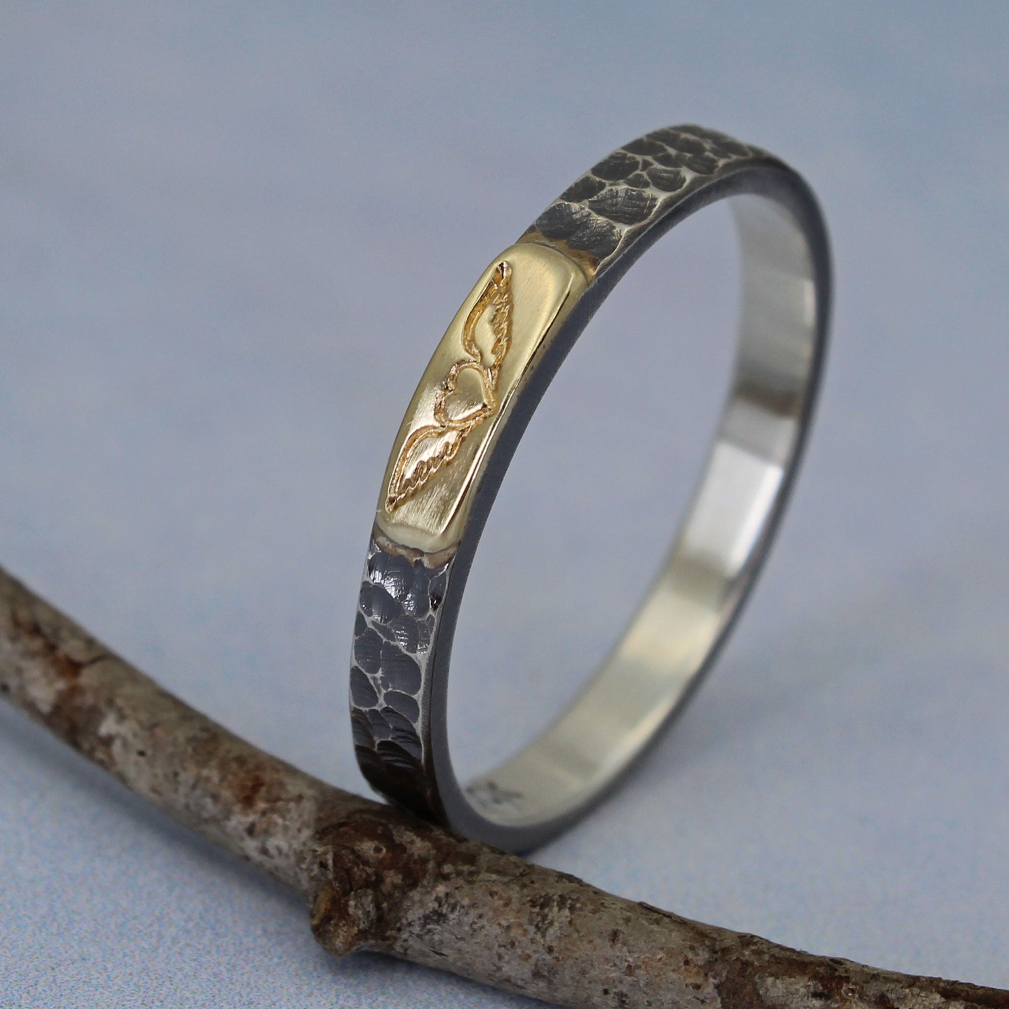 Sterling silver ring with winged heart design shown fro the side