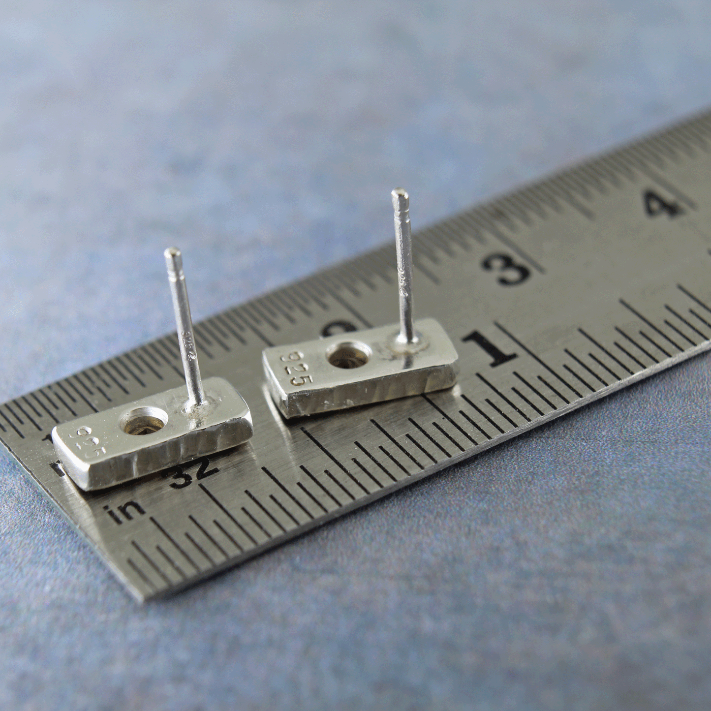 Stone set silver studs shown on ruler for size