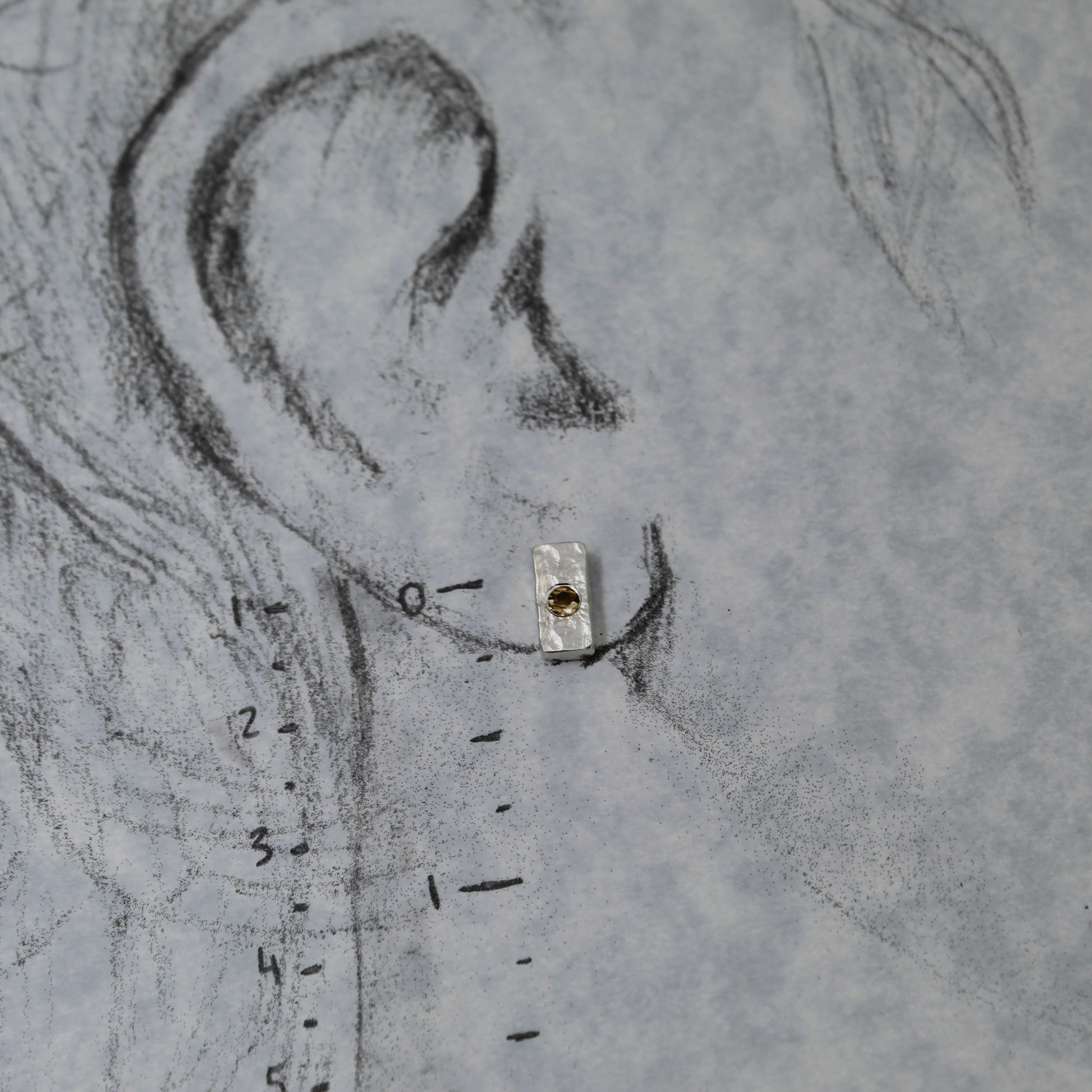 Silver citrine studs shown on life size ear drawing