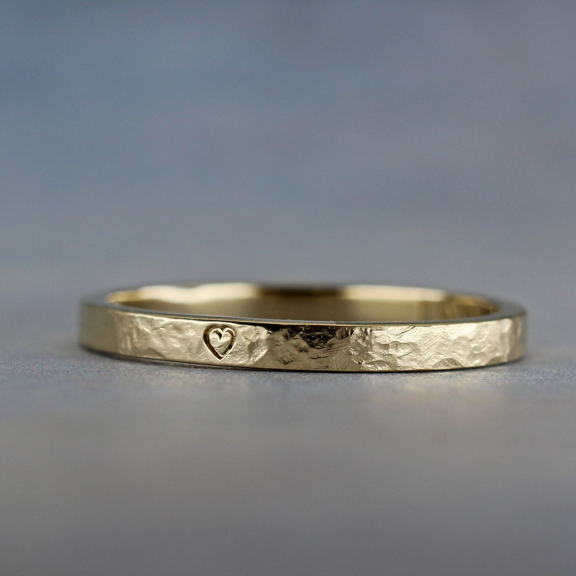 Engraved gold ring with custom inscription, shown with heart symbol