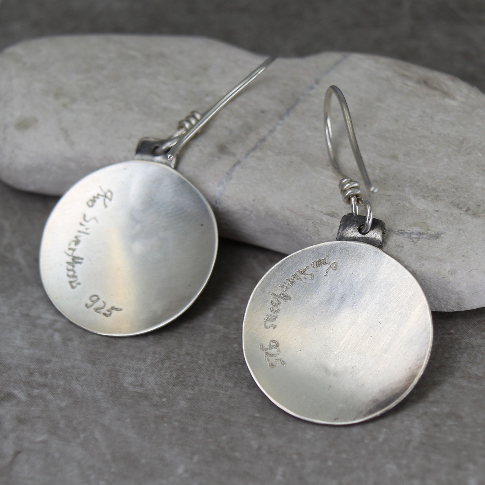 Earrings shown from the back with signature