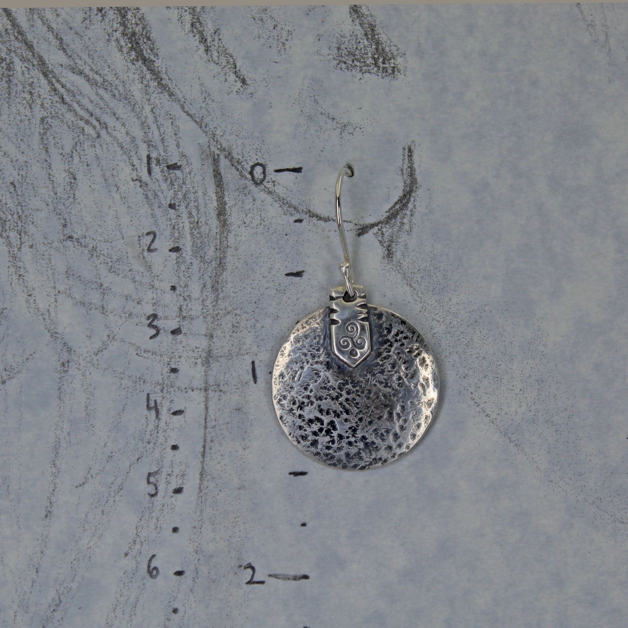 Celtic triskele earrings shown on a life size ear drawing with measurements.