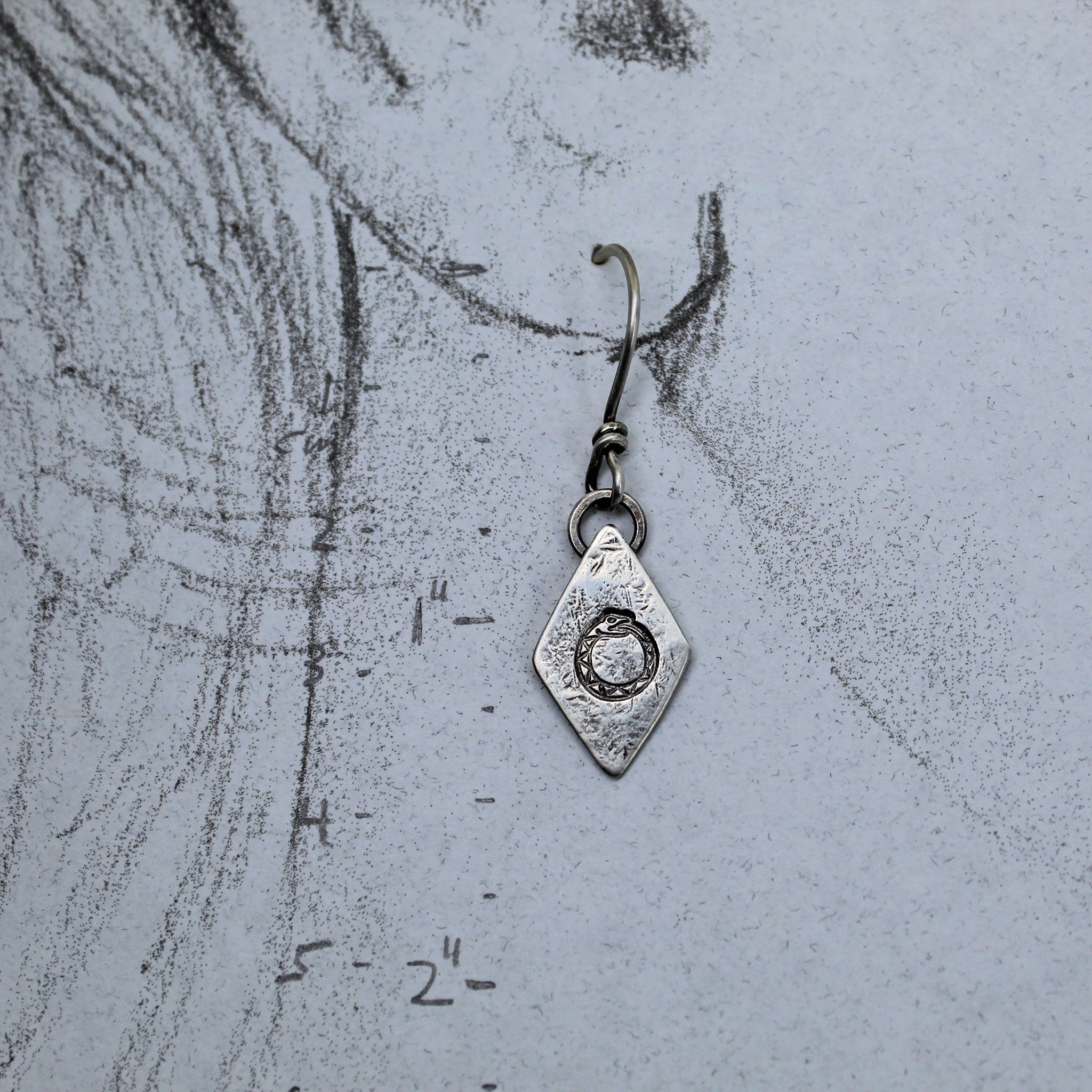 Sterling silver ouroboros earrings with measurements shown on ear drawing
