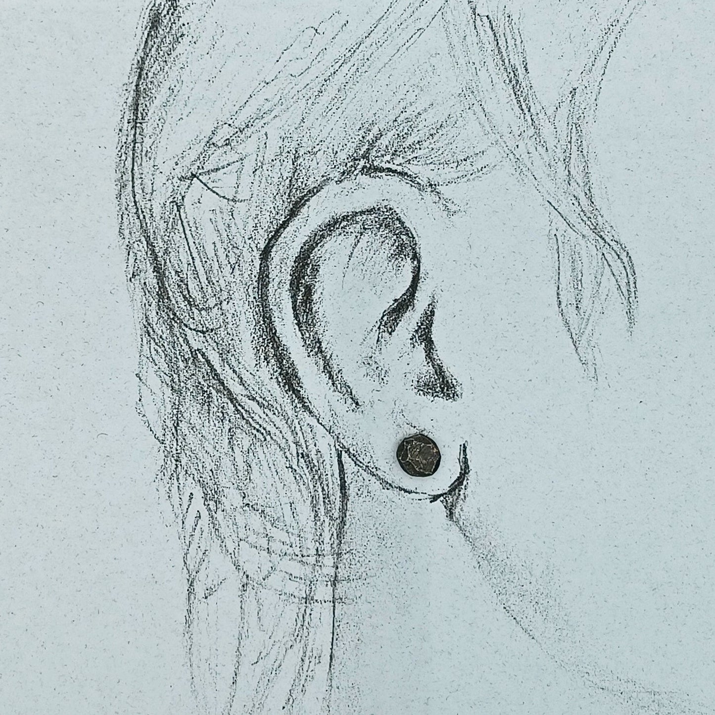 Dark silver studs shown in life size ear drawing