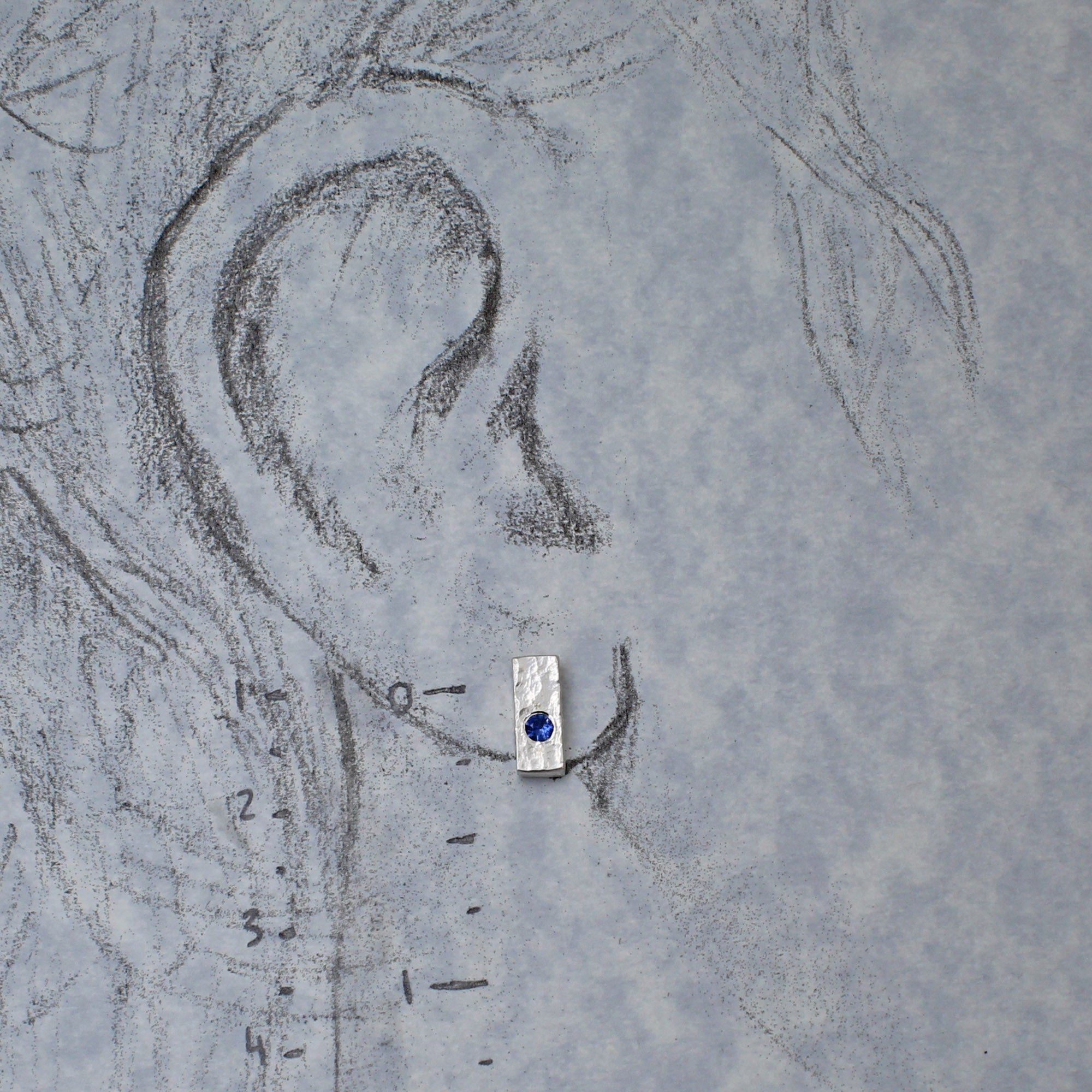 Silver post earrings show on drawn to scale ear