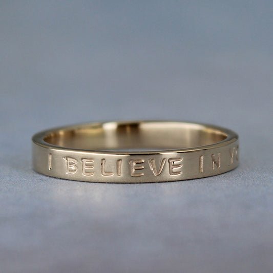 Minimalist gold ring with custom inscription on the outside